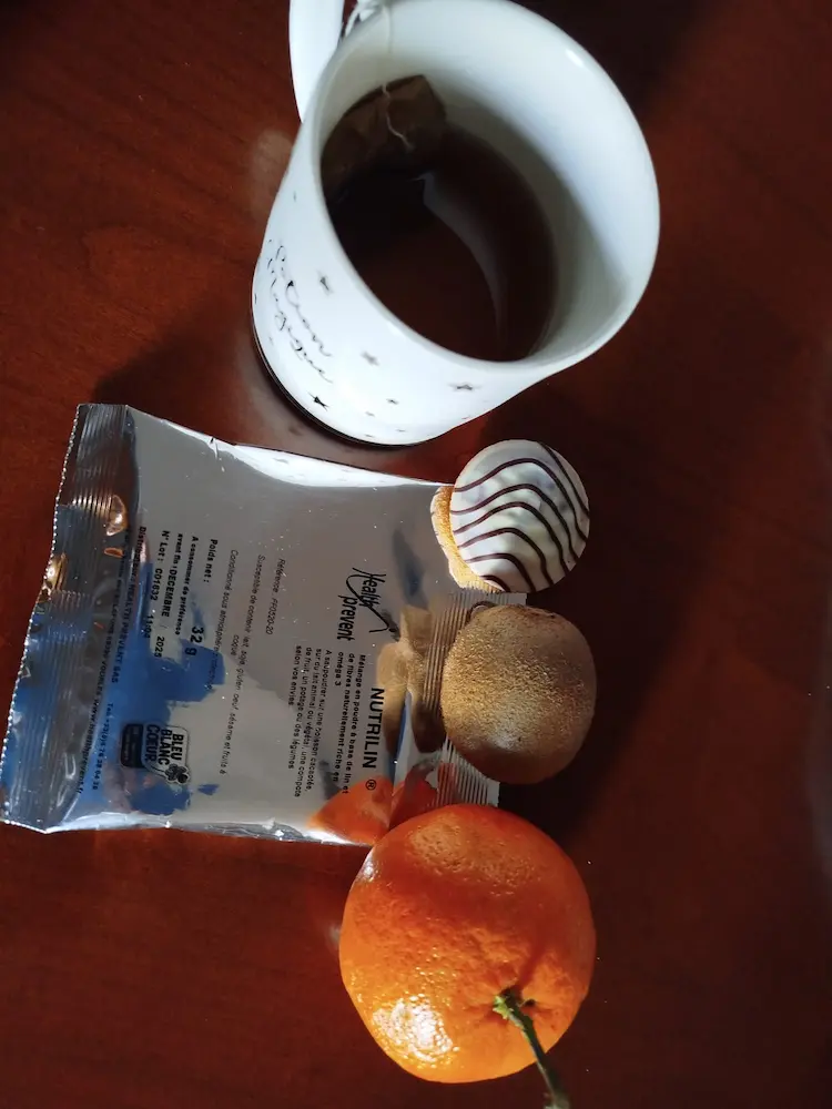 Un sachet de Nutrilin® mélangé à un thé vert, accompagné d’une orange.